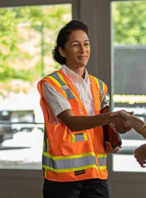 ServiceMaster Restore employee in vest shaking customers hands